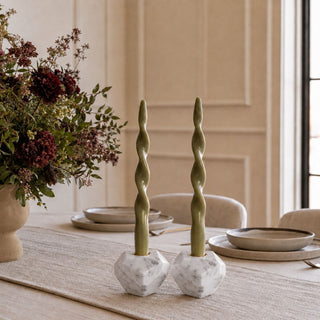 Olive Green Twisted Candle Taper Set of 2 styled on a dining table with white marble candle holders, a neutral runner, and a moody floral arrangement.