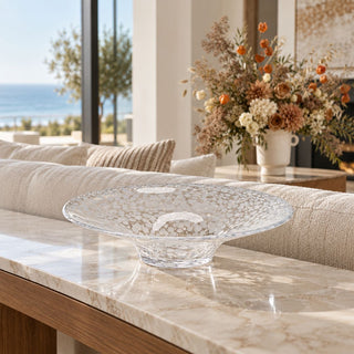 Opal glass centerpiece bowl on a marble console behind a sofa with dried flowers