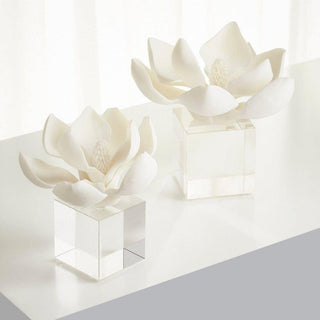 Two white resin magnolia sculptures displayed on solid crystal cube bases styled on minimalist white console table, elegant modern home decor from Third & Main