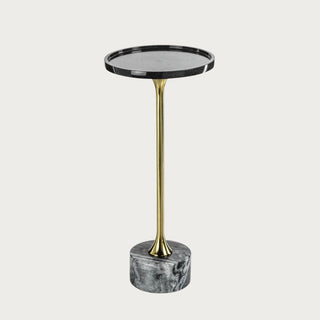 Black marble cocktail table with brass stem styled beside neutral sofa in curated living room