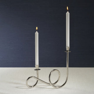 Polished nickel Breda two-tier candle holder with white taper candles styled on slate tabletop in contemporary setting.