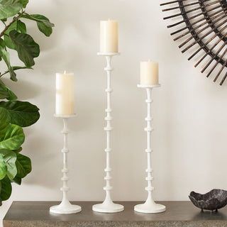 Set of three tall white aluminum pillar candle holders with a sculptural design, displayed with pillar candles (not included); ideal for modern or transitional or modern farmhouse home décor. Fall decor, Winter Decor, Holiday decor