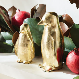 Pair of gold aluminum penguin figurines for festive winter and christmas home décor.