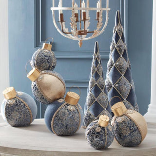 Set of blue and gold velvet tabletop ornaments and decorative cone trees beneath chandelier – elegant jeweled holiday décor for sophisticated winter home styling.