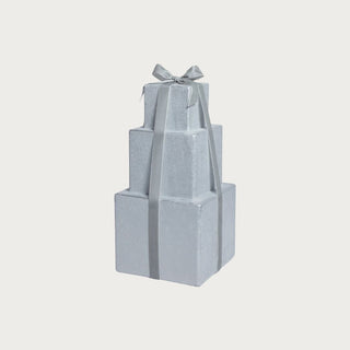 Set of elegant silver decorative gift boxes with gray ribbon in a modern holiday vignette.