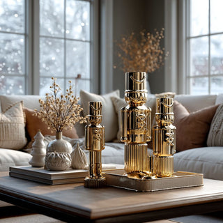 Set of gold ceramic soldiers in various sizes styled with books and vases displayed on coffee table in elegant neutral living room with holiday décor – reflective high-gloss nutcracker sculpture for sophisticated modern nutcracker holiday décor for luxury interiors 