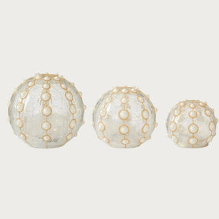 Set of three clear glass LED globes with gold glitter and pearl detailing on neutral background – elegant handcrafted crackled glass lighted spheres with built-in timer for holiday and year-round décor.