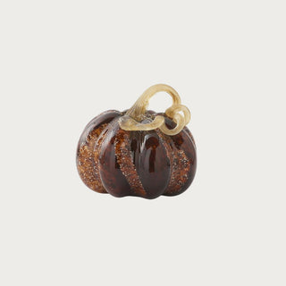 Small brown speckled handblown glass pumpkin measuring 4.75 inches high by 5 inches wide with warm amber variation and a looping glass stem.