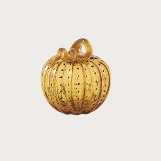 Small 6.25 inch handblown golden amber glass pumpkin with dark speckling, ribbed sides and a sculptural looping glass stem.