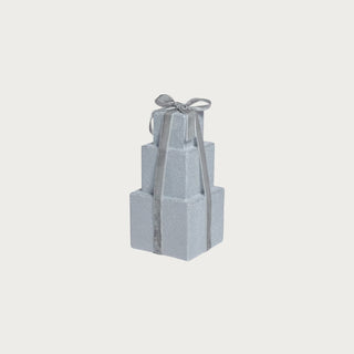 Small glittering silver stacked present décor with a satin gray ribbon, styled in an elegant modern winter vignette.