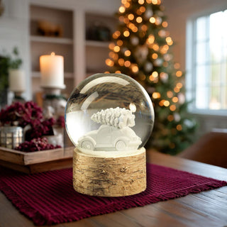 Snow globe with white car carrying Christmas tree on birchwood base — modern holiday decorative accent by Third & Main.