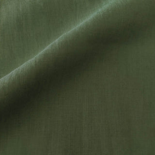 Close-up fabric swatch of the So Soft Linen Spruce Green pillow showing its deep green color and fine woven texture.