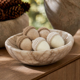 Styled 2 inch felt acorns in cream and light brown with knitted caps arranged in a marble bowl; sold individually in three neutral color options for fall decor.