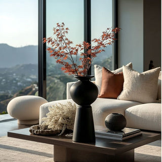 Styled Hinoki Matte Black vase with tall orange maple branches styled on coffee table in modern living room with neutral sofa and rust pillows