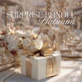 Surprise Bundle Platinum with a white gift box and gold ribbon on a blurred elegant setting.