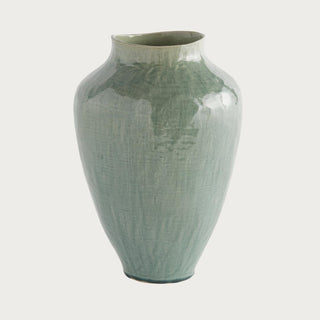 tall semi gloss green ceramic vase styled on console table with neutral decor and soft natural light