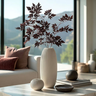 Tall ivory ribbed vase with faux dry burgundy cimicifuga stems – artificial fall foliage for coffee table styling in modern neutral living room.