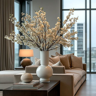 Tall white glass vase styled with blossom branches