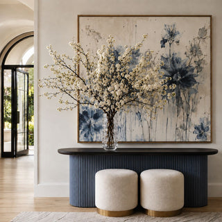 11.75-inch Clear Celeste Tall Vase/Hurricane by Third & Main styled on a dark fluted console table, filled with abundant white flowering branches. 