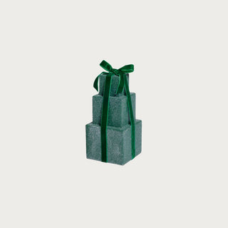 Three stacked gift boxes with a green ribbon on a light gray background.