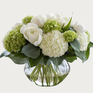 True Bloom Floral™ handcrafted hydrangea and rose arrangement in clear glass vase with visible stems and layered green and white real touch hydrangea