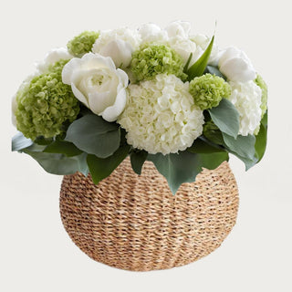 True Bloom Floral™ hydrangea and rose arrangement displayed in round seagrass vase featuring green and white real touch hydrangea with creamy Austin roses