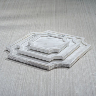 Three natural Volakas marble decorative trays stacked to show the 6.75-inch Small, 10.25-inch Medium, and 14-inch Large sizes with individual gray veining.