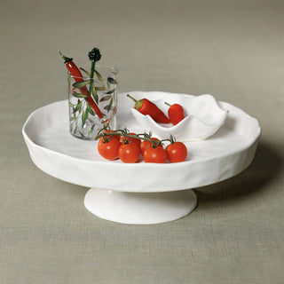 white ceramic footed serving tray with organic waved edge for entertaining fruit display and kitchen island styling