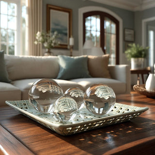 Woven square clay tray with open lattice design and soft neutral glaze, styled as a sculptural decorative accent placed on a living room coffee table with clear decorative orbs