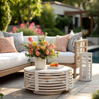 Woven leather hurricane styled outdoors next to white patio seating and florals”