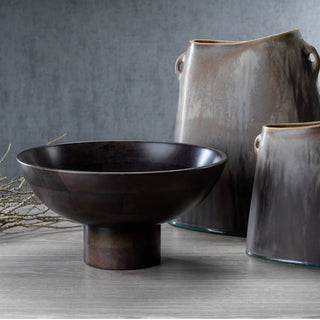 arge pedestal mango wood bowl with dark finish displayed on console with ceramic vases and natural branch for modern organic styling.
