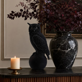 18.25-inch black velvet-flocked owl sculpture styled on a dark console with candlelight, black marble vase, and deep burgundy fall branches.