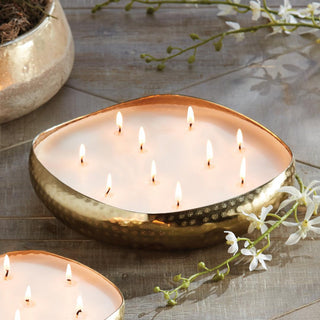 Cashmere 10-wick candle in a gold tin styled and lit on a table, Third & Main
