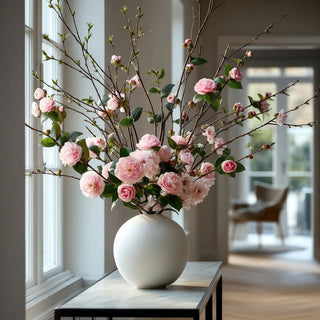 30 inch faux pink camellia stems styled with pink cherry blossom branches in a ceramic vase on an entryway table