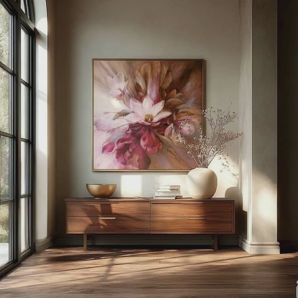 Short display video of the Magnolia Power wall art by Kate Tova styled above a warm wood entryway console in a luxury California home, featuring pink and burgundy magnolia florals in a gold frame with soft natural light and minimal contemporary decor.