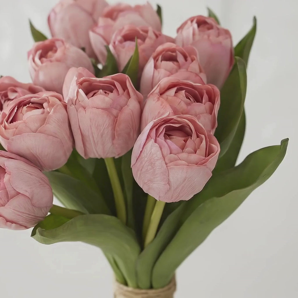 6_Stem_Warm_Coral_True Bloom Real_Touch_Tulip_Bundle by_Third_Main with a woman's hand gently touch the petals to showcase the realistic look and feel of these artificial flowers