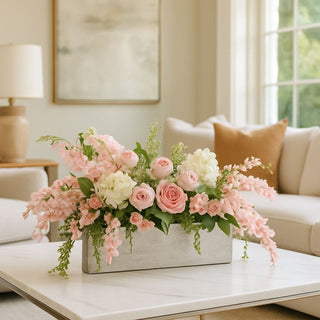 Silver aluminum Joss Vase styled with pink wisteria and trailing pink roses on a table in a contemporary living room