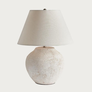 The Theo Table Lamp with textured ceramic body and linen shade, styled on a console table with neutral decor and soft ambient lighting