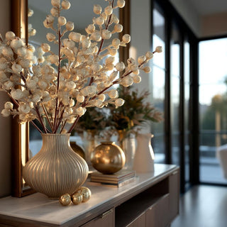 uxury holiday floral arrangement using crystal beaded champagne gold stems styled in a ribbed metallic vase on a modern console table in a bright Sausalito California contemporary home, golden hour lighting with sophisticated Christmas décor, Third & Main elevated seasonal styling